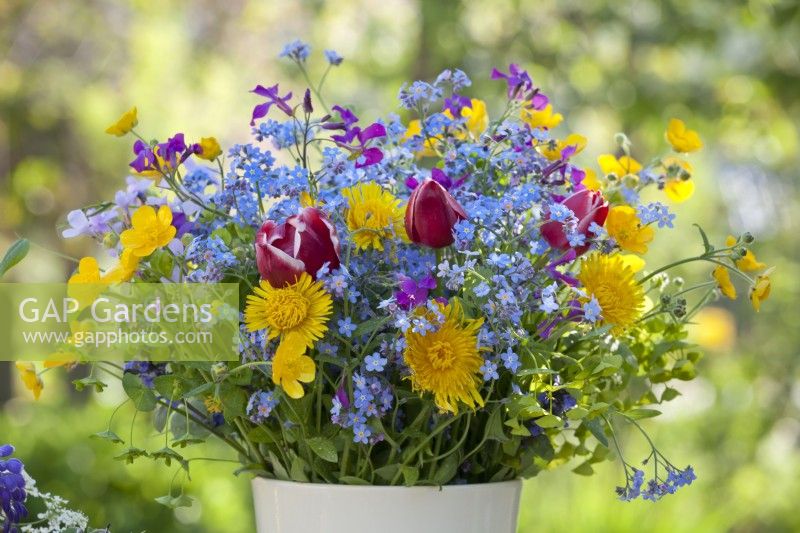 Flower bouquet containing tulips, honesty, dandelion, buttercups and forget me nots.