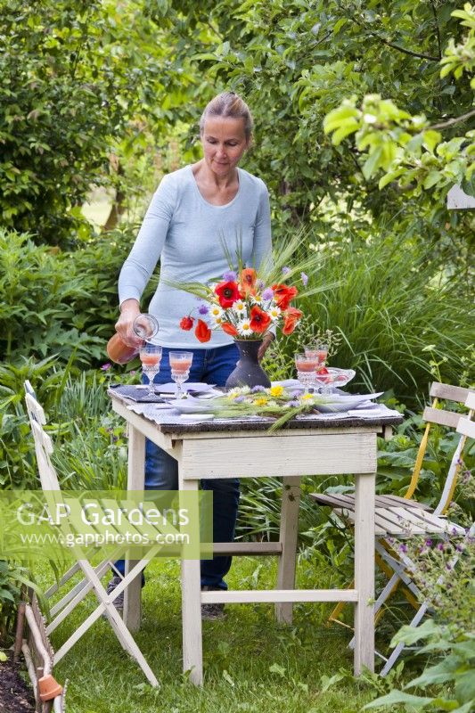 Woman setting up table for outdoor dinner.