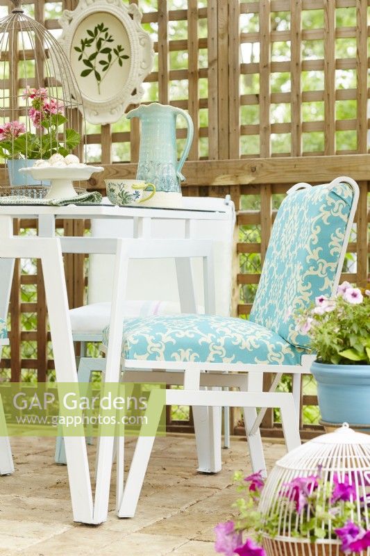 Vintage table and chairs painted in blue and white on trellised patio