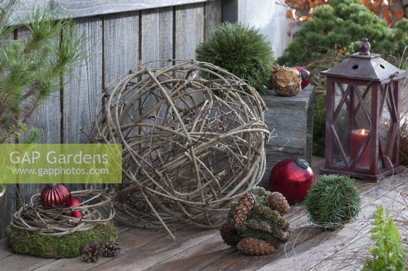Ball of clematis vines with Christmas tree ornaments, moss wreath, and lantern