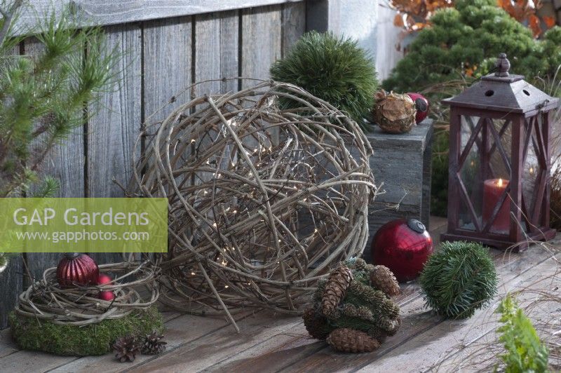 Ball of clematis vines with fairy lights, Christmas tree ornaments, moss wreath, and lantern