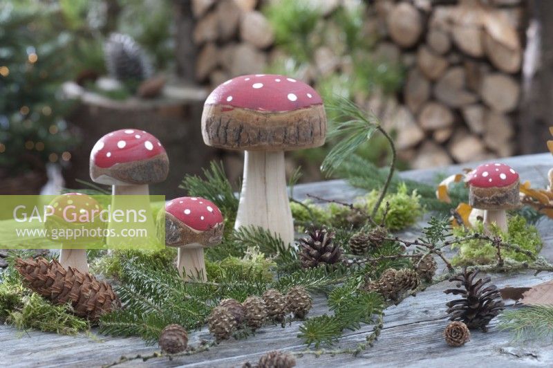 Forest display with toadstools made of wood, fir branches, and pinecones