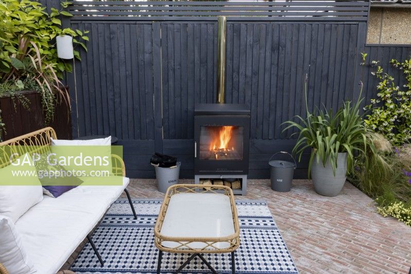 Log burner in patio area in suburban garden
