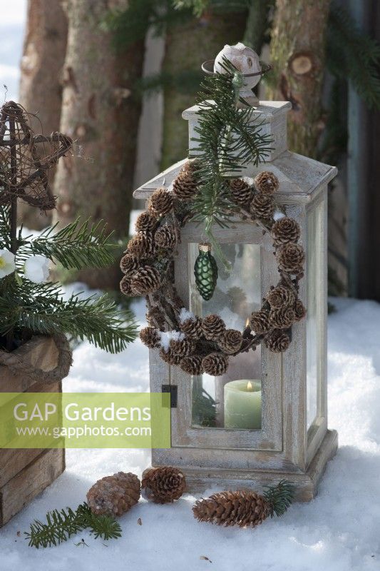 Lantern with a wreath of larch cones, fir branch, and Christmas tree decorations