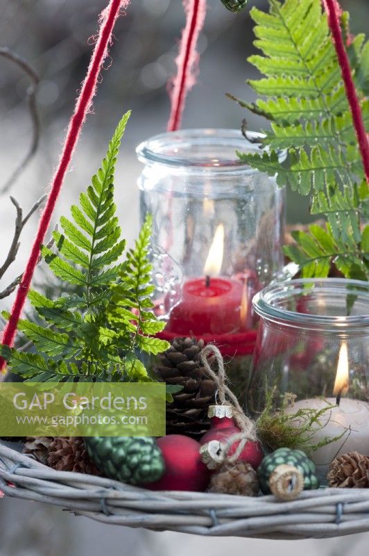 Hanging Christmas decoration with lanterns, fern leaves, Christmas tree decorations and cones