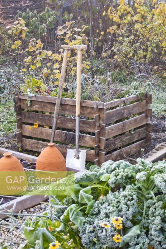 Kitchen garden with raised bed, compost heap and tools.