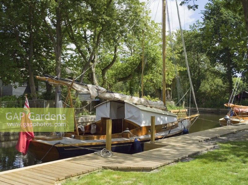 Private quay heading in garden with classic broads sailing boat - Ludham Norfolk