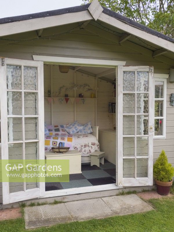  View through open doors to interior of summerhouse in garden