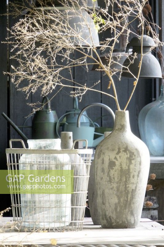 Decorated garden room with vases on table and rustic lamps.