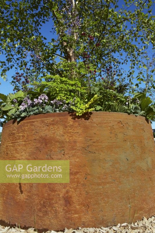 Circular reclaimed industrial planter in The Vitamin G Garden at RHS Hampton Court Palace Garden Festival 2022. Summer. July.