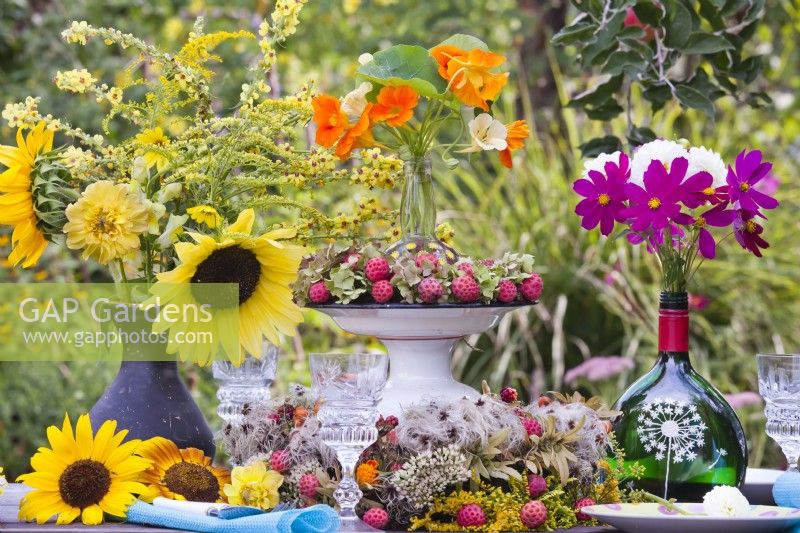 Outdoor floral arrangement with nasturtium, hydrangea, sunflowers, Cosmos bipinnatus and Cornus kousa berries.