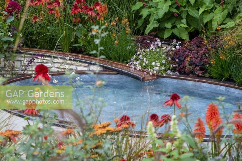 Copper water rill running into a raised pond surrounded by colourful planting - Finding Our Way: An NHS Tribute Garden, RHS Chelsea Flower Show 2021