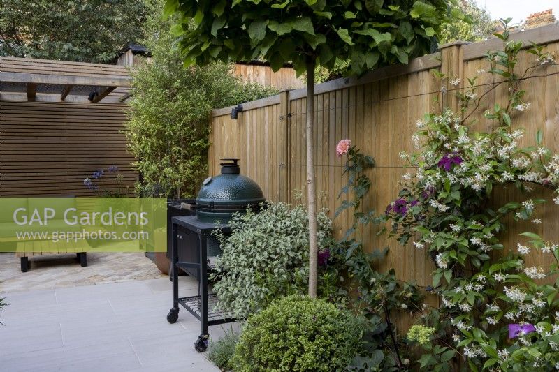 Patio area with barbecue and contemporary wood boundary fence