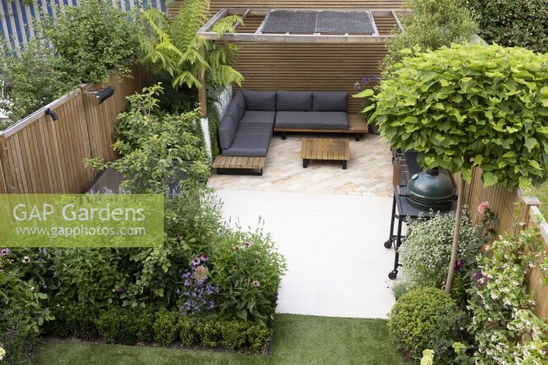 High view of secluded suburban garden with patio and wood pergola