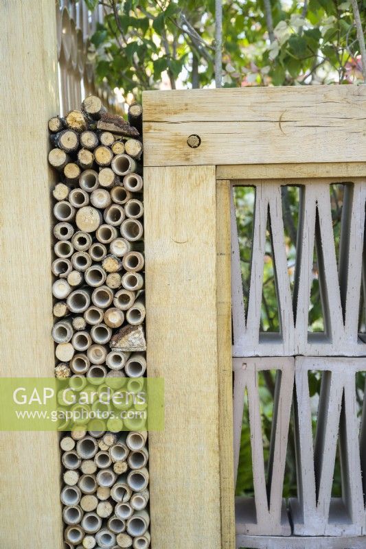 Insect hotel built in fence in The Wooden Spoon Garden at RHS Hampton Court Palace Garden Festival 2022 - design:  - Toni Bowater and Lucy Welsh
