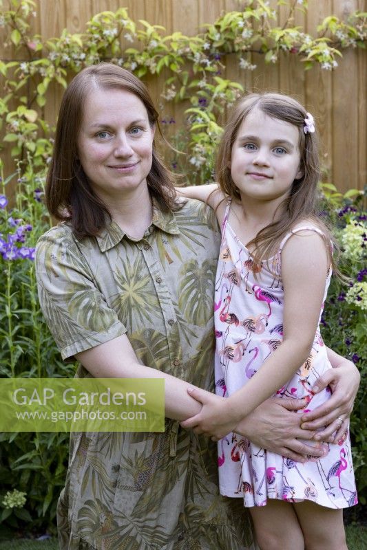 Portrait of mother with young daughter in garden