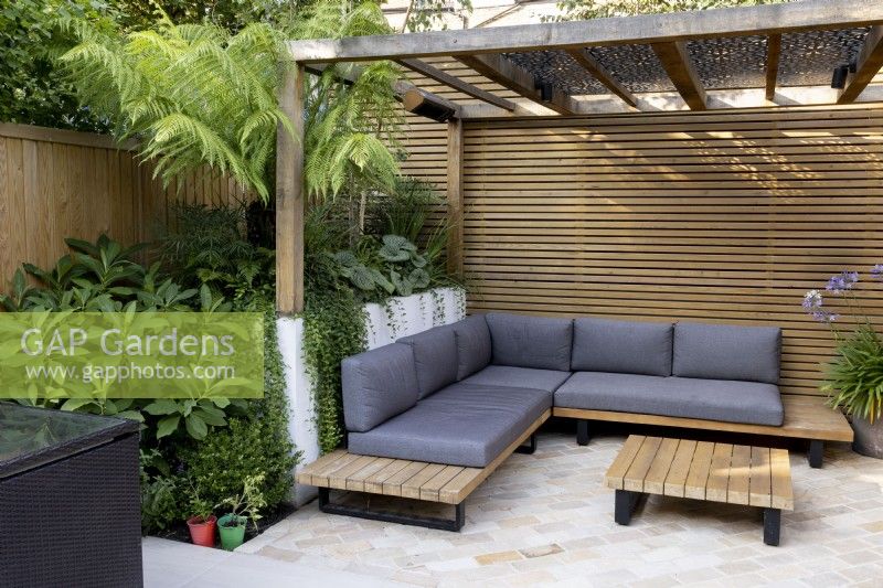 Contemporary patio area with wood pergola and seating with cushions