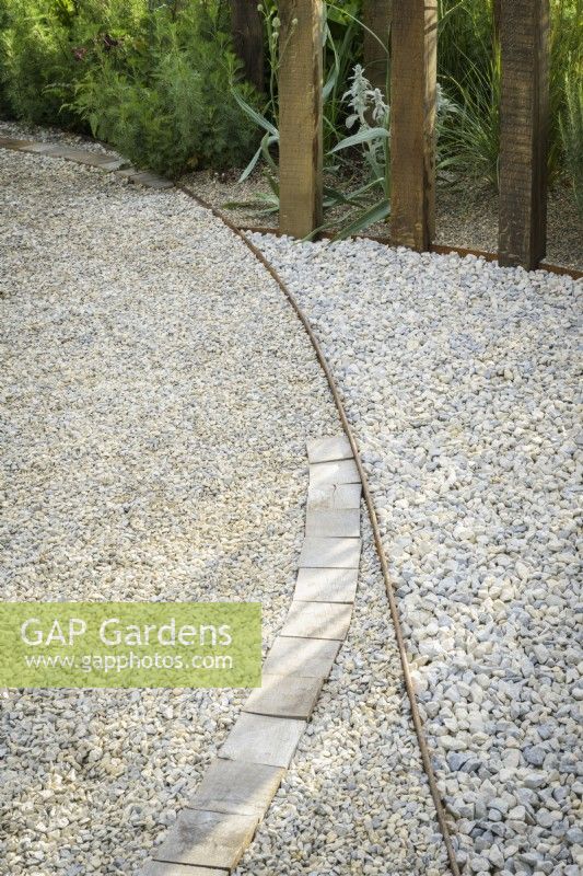 Detail of gravel path with wooden pattern and edging in A Journey, in Collaboration with Sue Ryder garden at RHS Hampton Court Palace Garden Festival 2022 - Designed by Katherine Holland