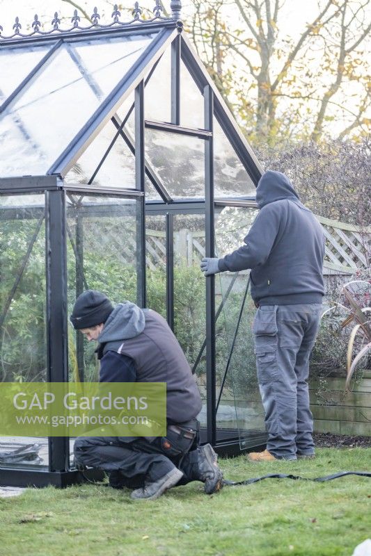 Men placing glass in the greenhouse