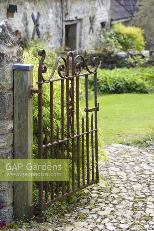 Gate between garden areas in a country garden in April.