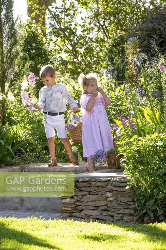 Boy and girl picking flowers in a garden