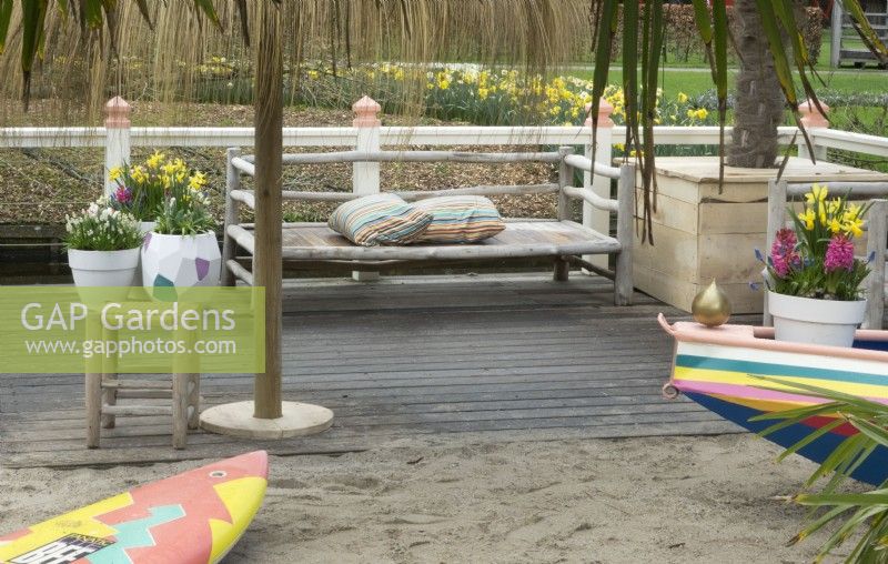 Inspiration Beach garden with wooden bench at Keukenhof. Containers filled with spring flowers.