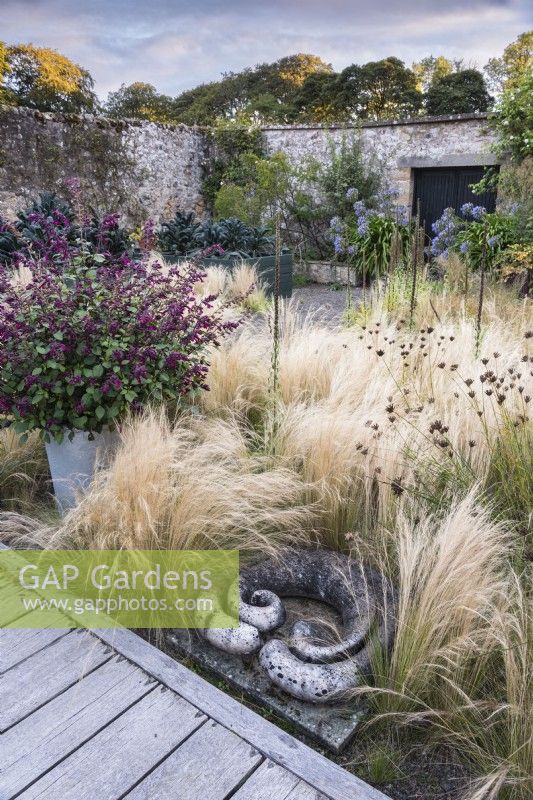 Stone sculpture surrounded by Stipa tenuissima at Whitburgh Walled Garden in September