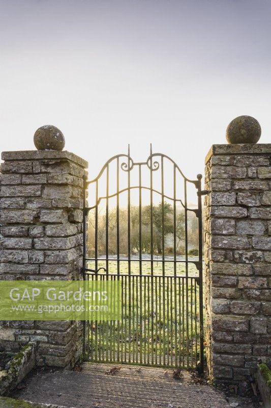 A gate leading out of the garden into the surrounding countryside at Cotswold Farm Gardens in February.