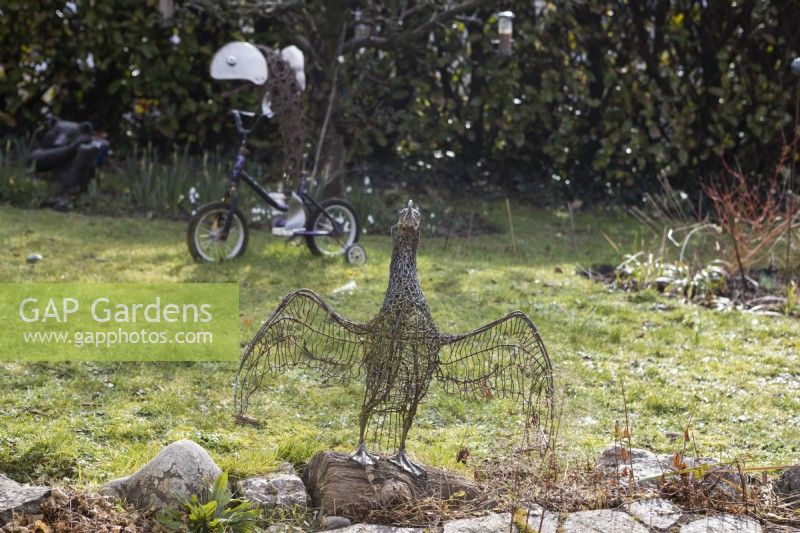 A cormorant with wings unfurled, sculpture made from recycled wire and mesh.  With Pike on a Trike, made from recycled bicycle and other assorted parts, by Daren Greenhow, in the background. February. 