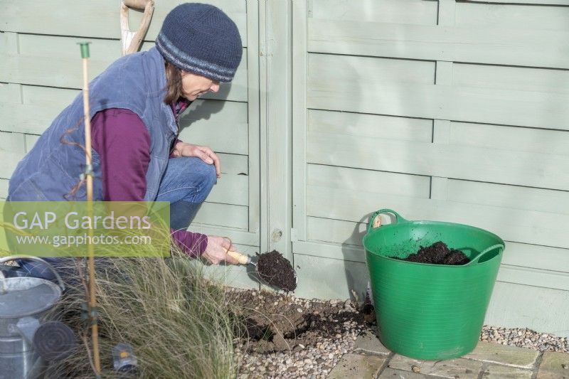 Woman placing compost at the bottom of the hole