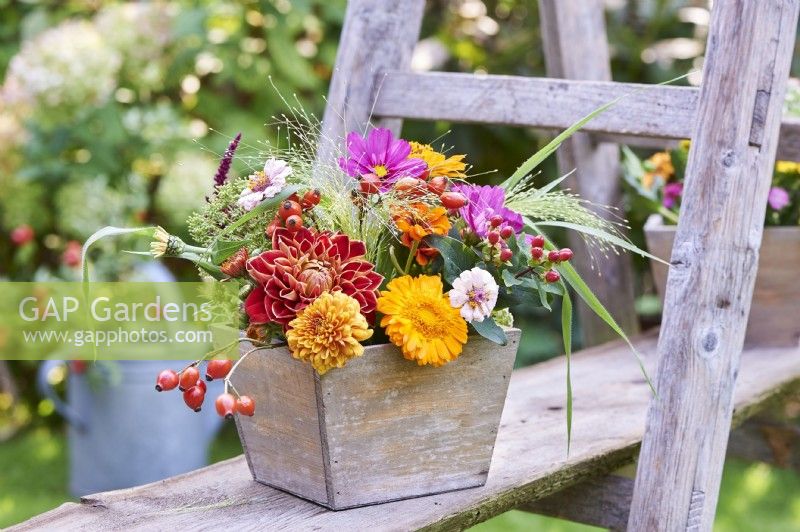Late summer bouquet with dahlia and calendula in a wooden box 