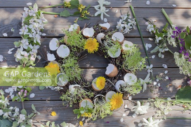 Wreath featuring egg and snail shells with cress and dandelion flowers.
