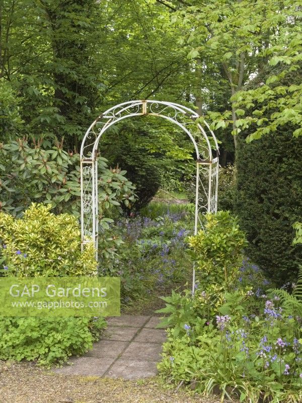 Entrance to woodland garden via  metal arch