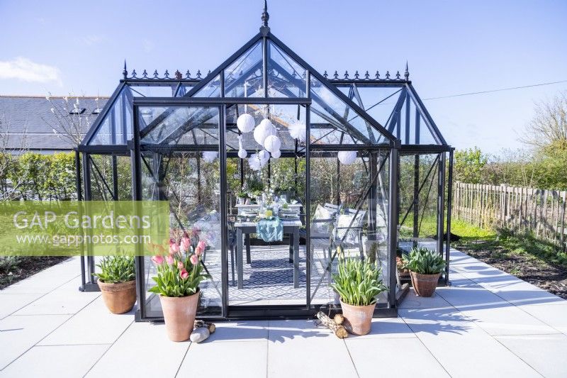 Greenhouse with decorated table and hanging paper pom poms