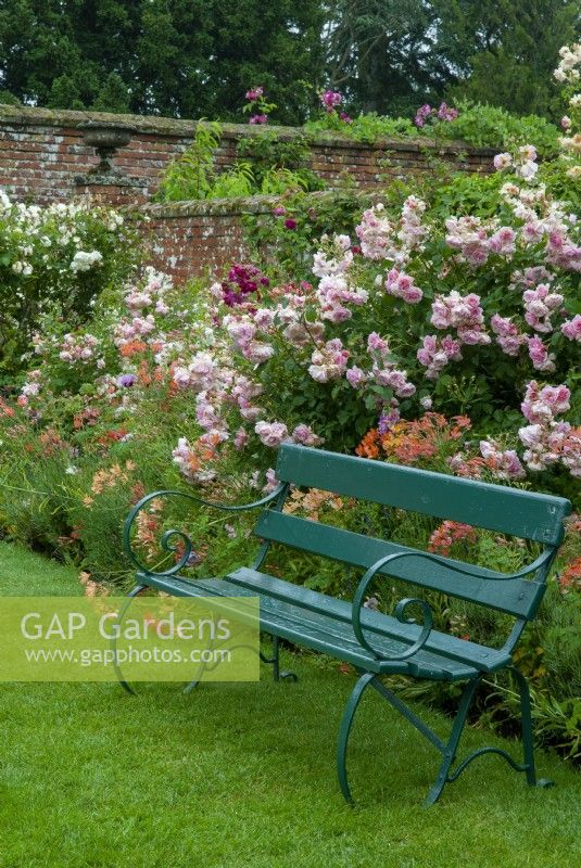 Green bench against border of Roses and Alstroemerias - Helmingham Hall, Suffolk