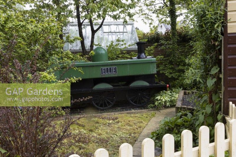 The Railway Children garden with a steam train and carriage, signal box and humpbacked bridge. Recreated from the Hampton Court RHS Gold Medal Show Garden/Best in Show 1997. Trago Mills show gardens, Devon, UK. May. Spring