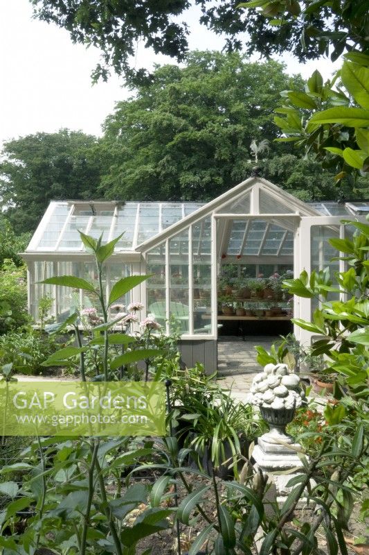 Victorian greenhouse and sculpture in foreground.