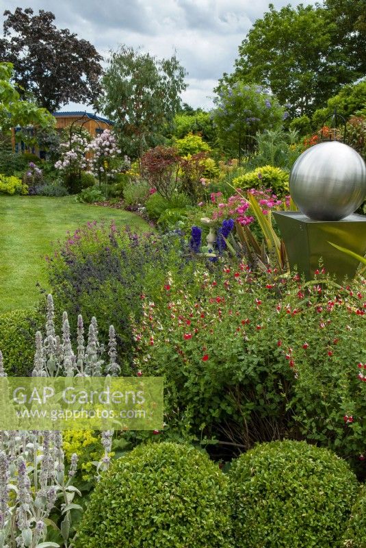 Deep perennial border with modern sculptural feature - Open Gardens Day, Tuddenham, Suffolk