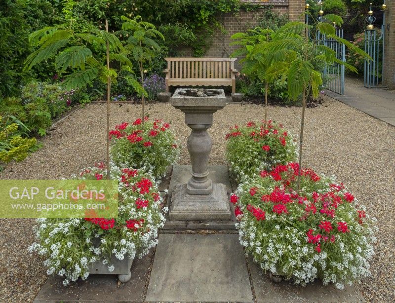 Entrance Court at East Ruston Old Vicarage Gardens, Norfolk July Summer. Formal arrangement of planters around a centrally-placed bird bath