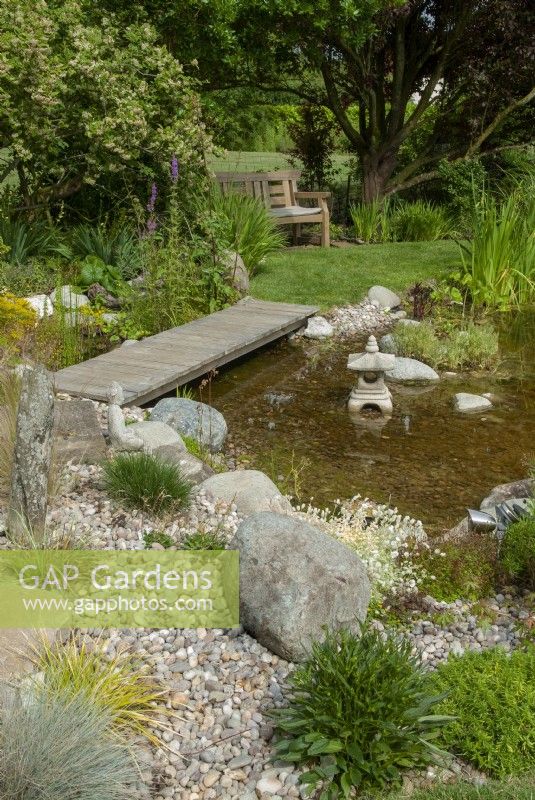 Footbridge over garden pond leading to seat beyond - Open Gardens Day, Worlingworth, Suffolk