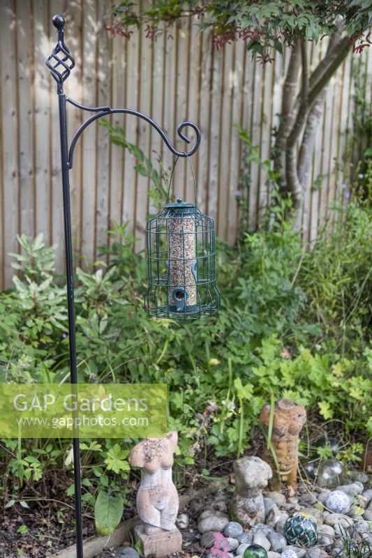 Bird feeding station with seeds in squirrel proof feeder, July