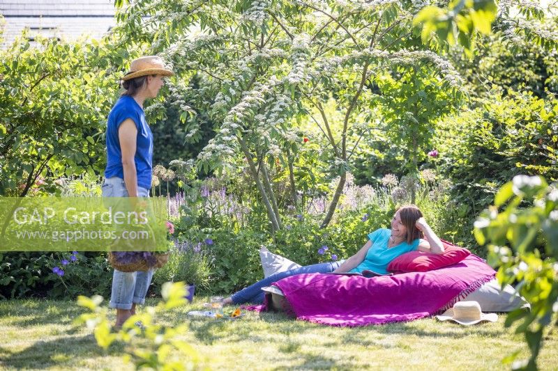 Women chatting while one relaxes on large bean bag