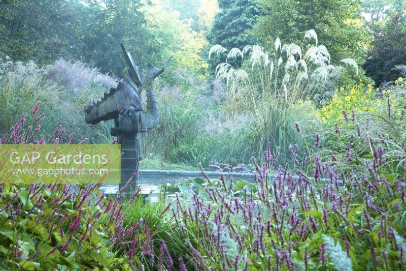 Sculpture in the centre of the Dragon Pond surrounded by Persicaria and ornamental grasses 