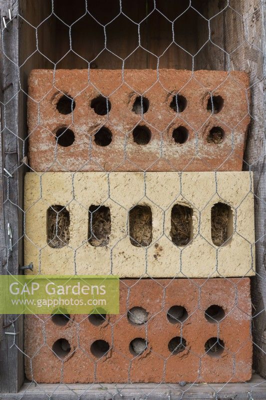 Bug hotel made from clay bricks with drilled holes for insects to hide and hibernate.