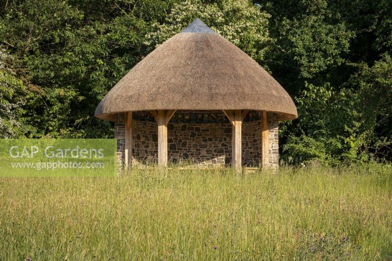 The Orchard Shelter at Rosemoor Gardens, RHS, Devon, a thatched traditional barn style building overlooking the apple orchards.