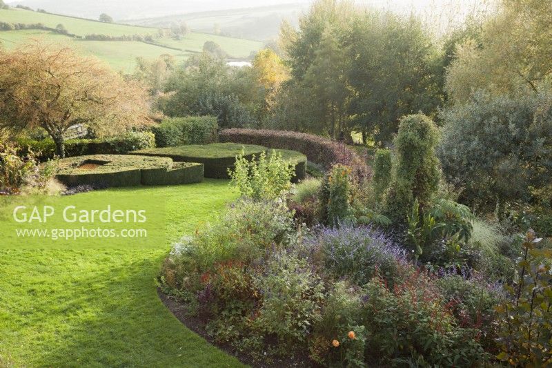 Aerial view of garden with countryside views. Borders contain Salvia 'Phyllis' Fancy' and Salvia confertiflora.