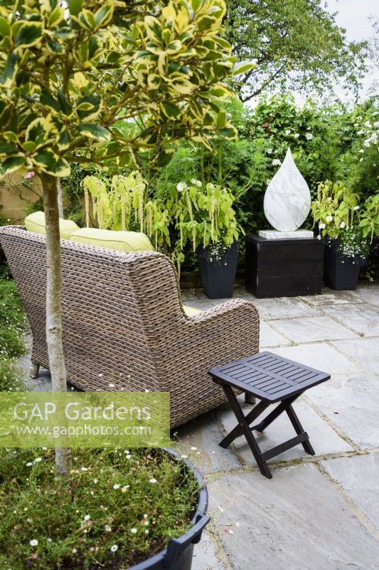 Rattan seat and table on a terrace in a September garden