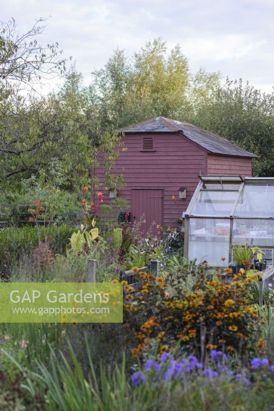 Painted granary surrounded by lush planting in September