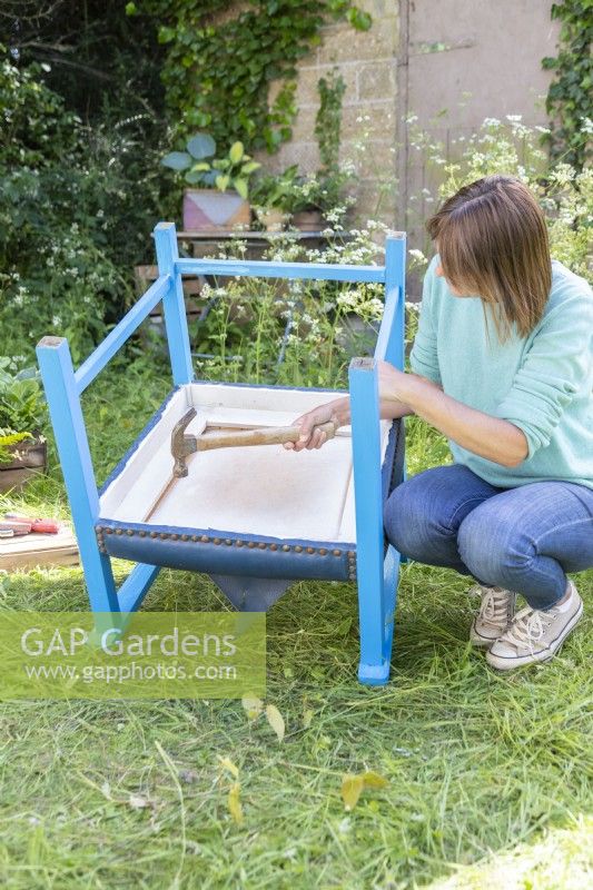 Woman using hammer to remove base seat base from chair