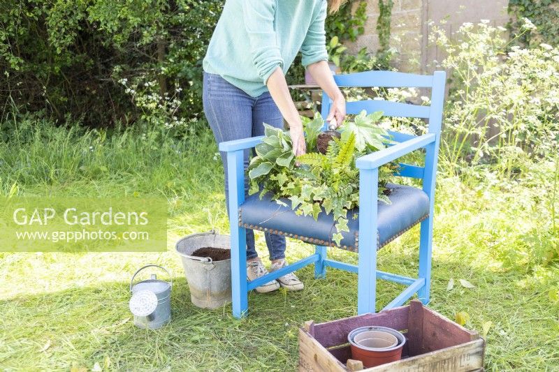 Woman backfilling chair container with compost